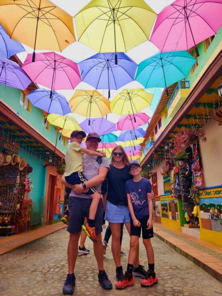 a family standing in Guatape under the colorful umbrellas